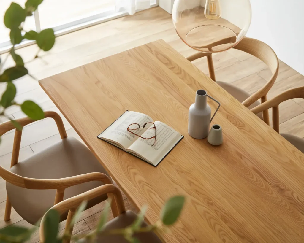 白い天板と天然木の脚を持つ楕円形ダイニングテーブルと天然木チェア、ベンチが配置されたダイニングルーム。身長別の差尺の目安を理解するための参考画像。