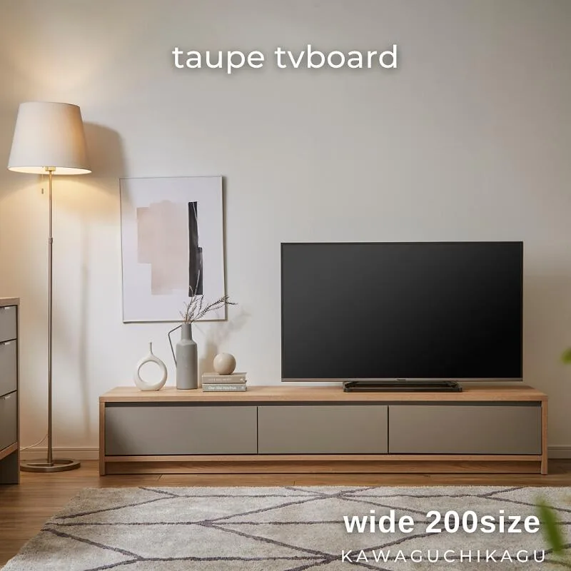 高さを抑えたグレージュ系のtaupeテレビボードに黒いテレビをのせた実例。上部に壁の余白が広がり、テレビボード ソファ 色 バランスの参考になる