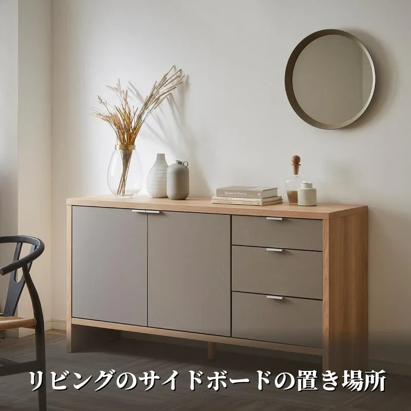 リビングの壁際に置いたtaupeサイドボード150cm。木の天板とグレージュの扉で、上に花器と本を並べた設置例