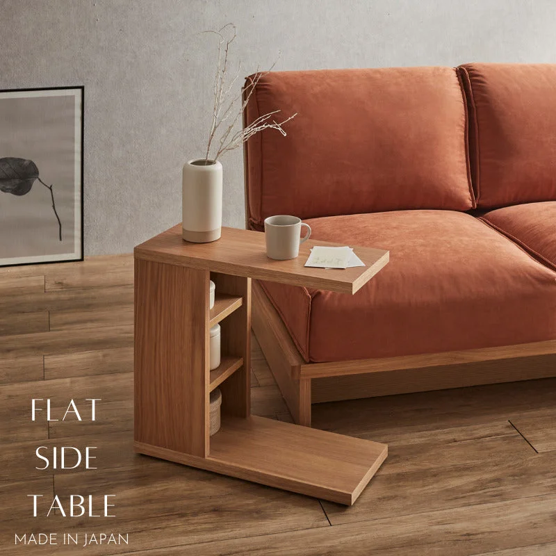 オレンジのソファの横に置いたFLATサイドテーブル。コの字形で、天板がソファの座面の上へ張り出し、脇に3段の棚がある