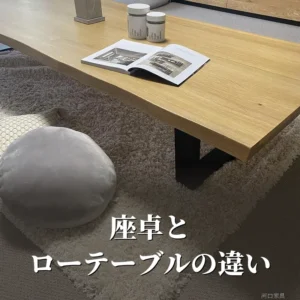 ラグの上に置いたKT座卓。木目の天板と黒い脚の座卓の横に、床に座るための丸いクッションがある